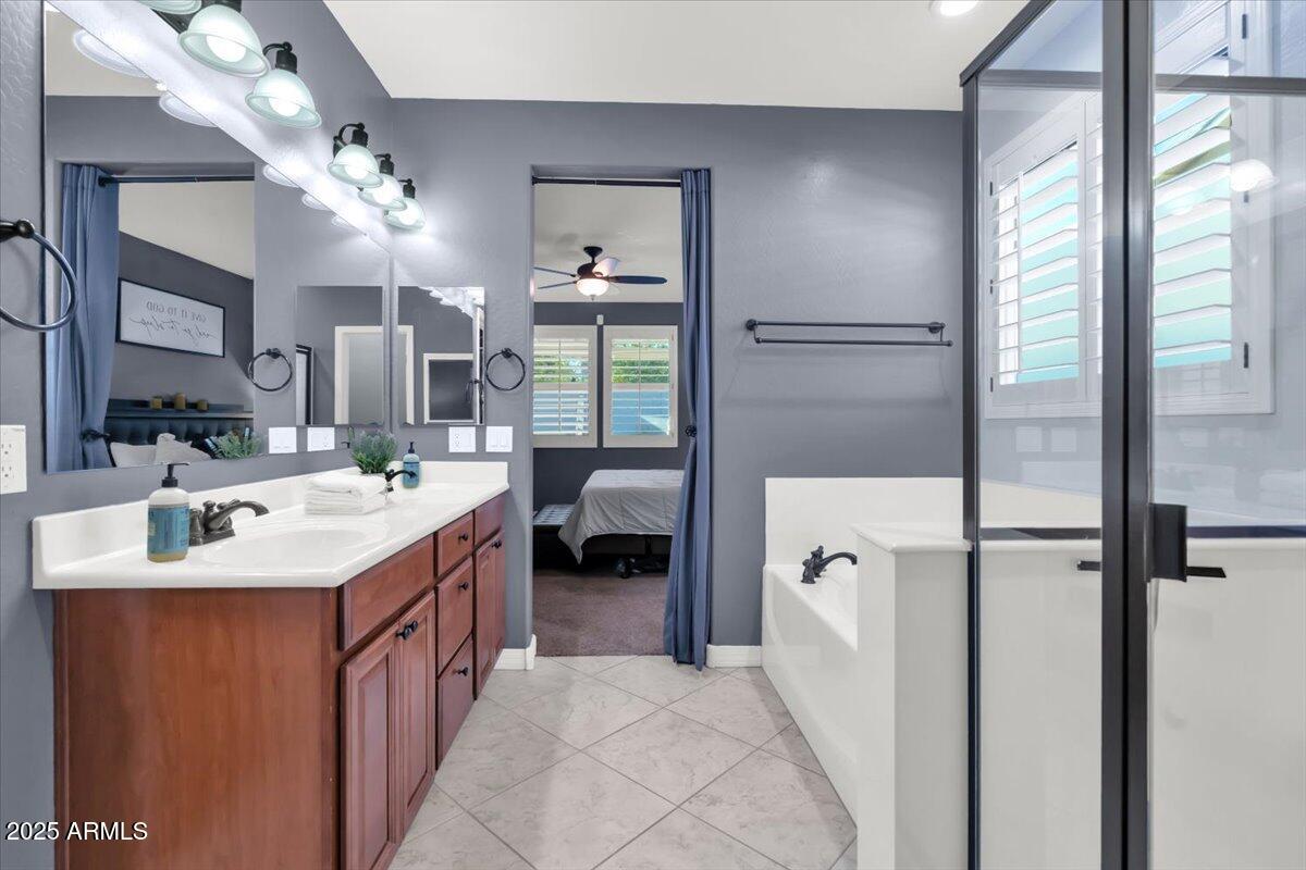 3214 North Springfield Street Buckeye, AZ 85396 - Photo 20 of 64 a en suite bathroom with a double vanity sink a mirror and a shower