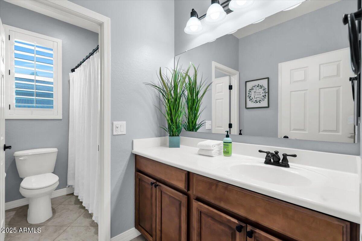 3214 North Springfield Street Buckeye, AZ 85396 - Photo 28 of 64 a bathroom with a toilet a sink and mirror