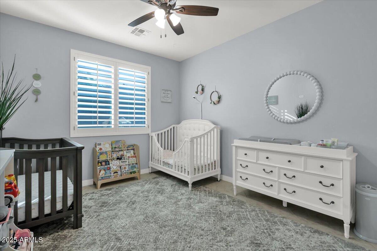 3214 North Springfield Street Buckeye, AZ 85396 - Photo 30 of 64 a spacious bedroom with a bed and a chandelier