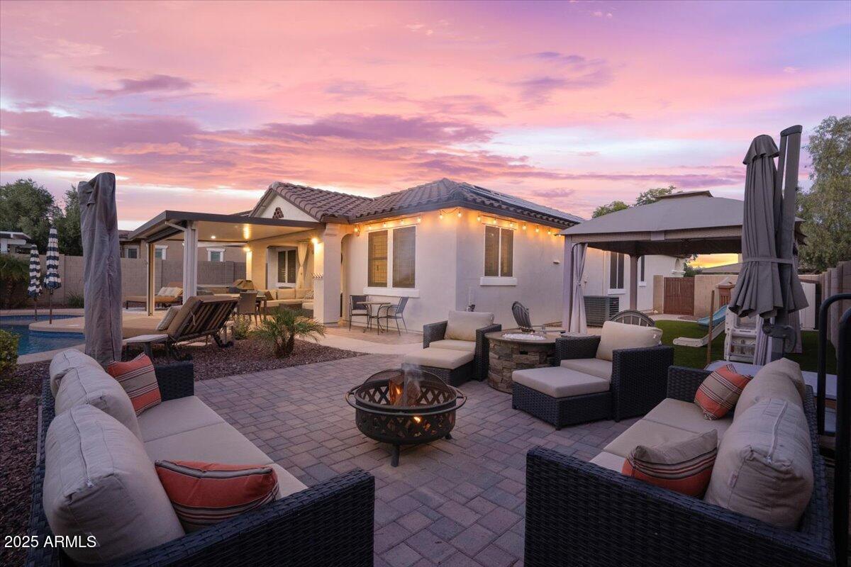 3214 North Springfield Street Buckeye, AZ 85396 - Photo 47 of 64 a view of a patio with couches table and chairs under an umbrella
