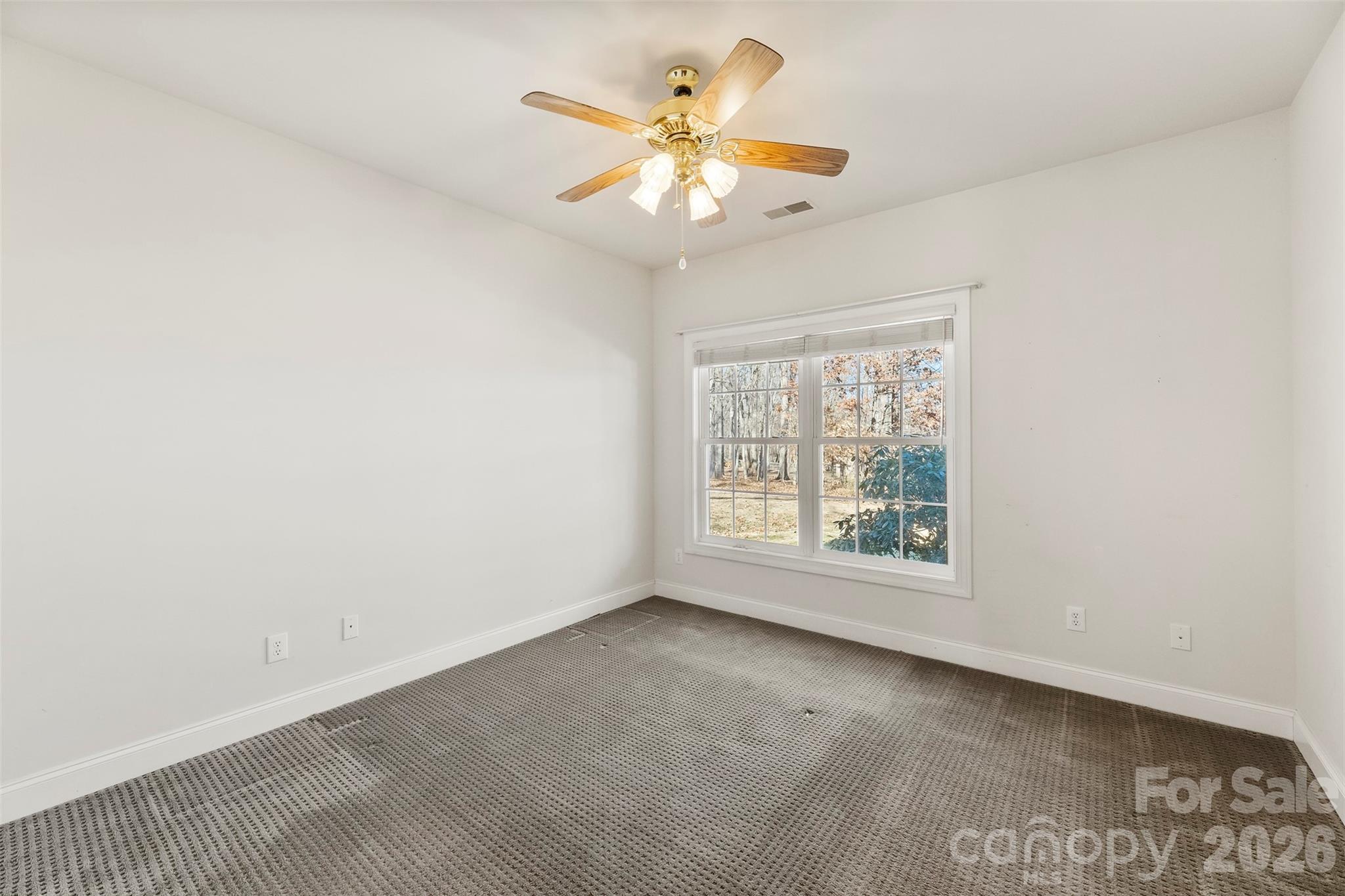 17858 Red Ridge Court Locust, NC 28097 - Photo 11 of 44 an empty room with a window and a ceiling fan