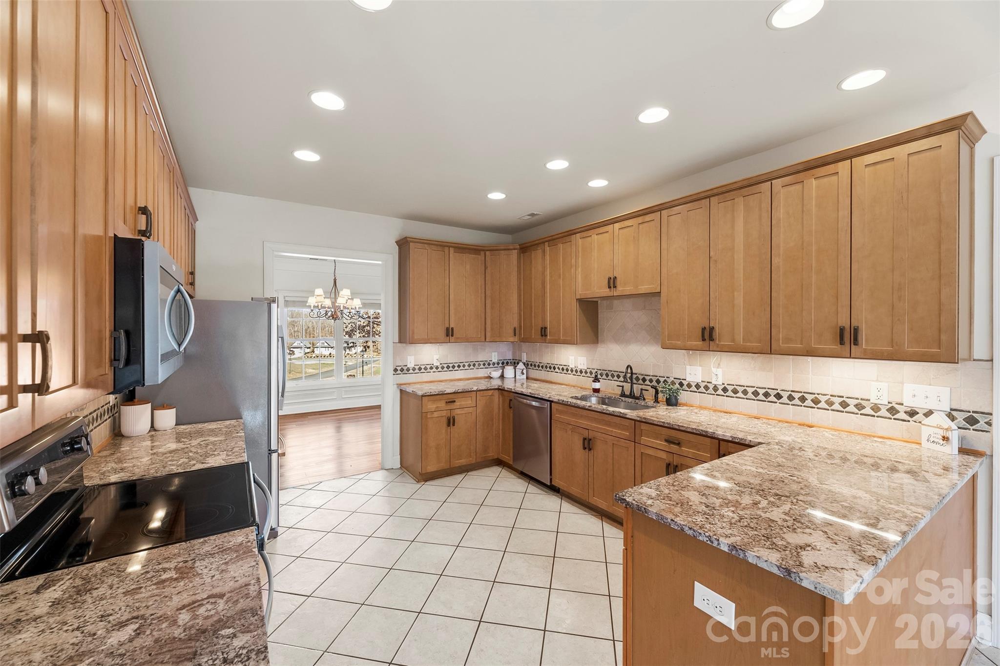 17858 Red Ridge Court Locust, NC 28097 - Photo 18 of 44 a kitchen with stainless steel appliances granite countertop a stove a sink and a microwave