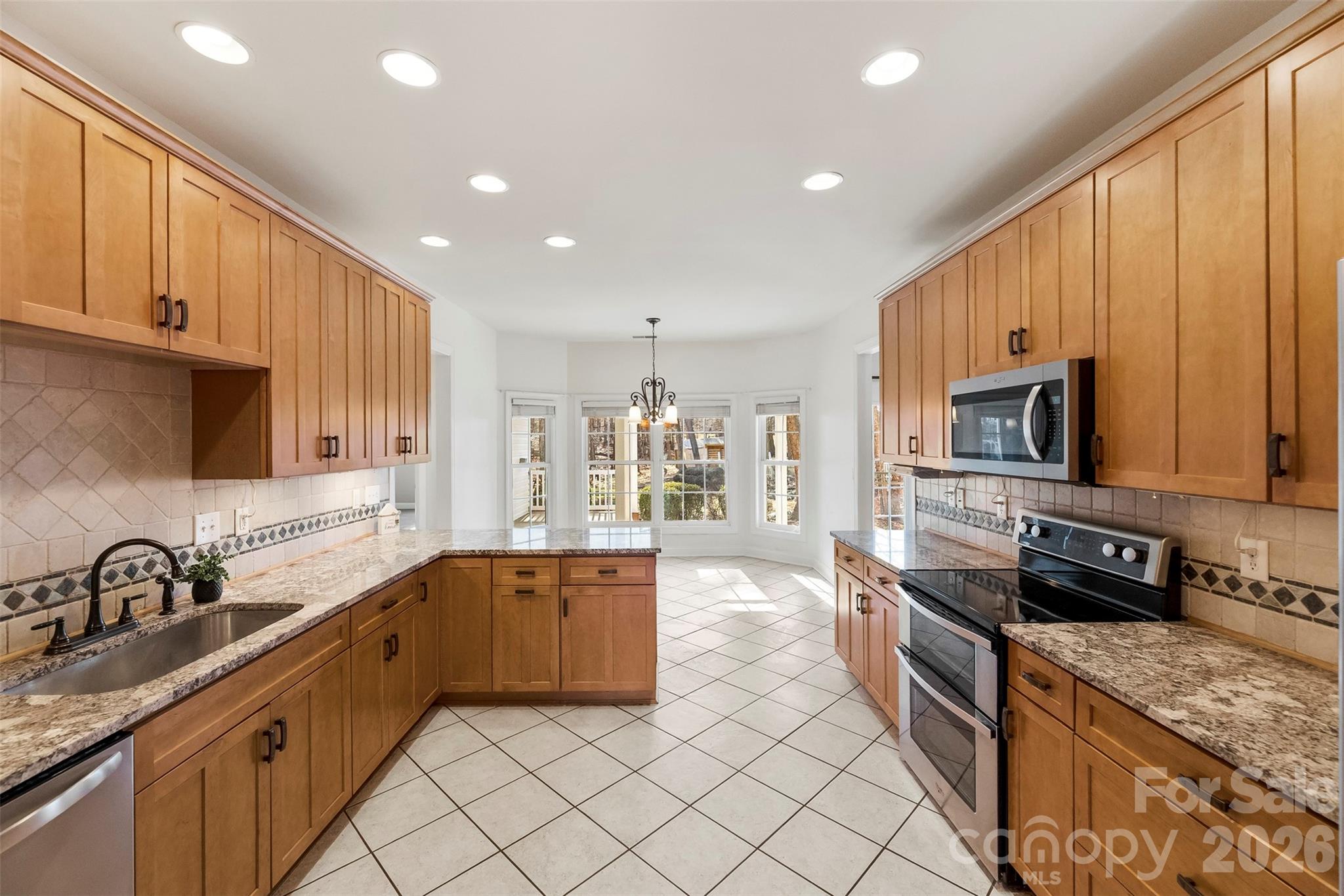 17858 Red Ridge Court Locust, NC 28097 - Photo 19 of 44 a large kitchen with stainless steel appliances granite countertop a sink and cabinets