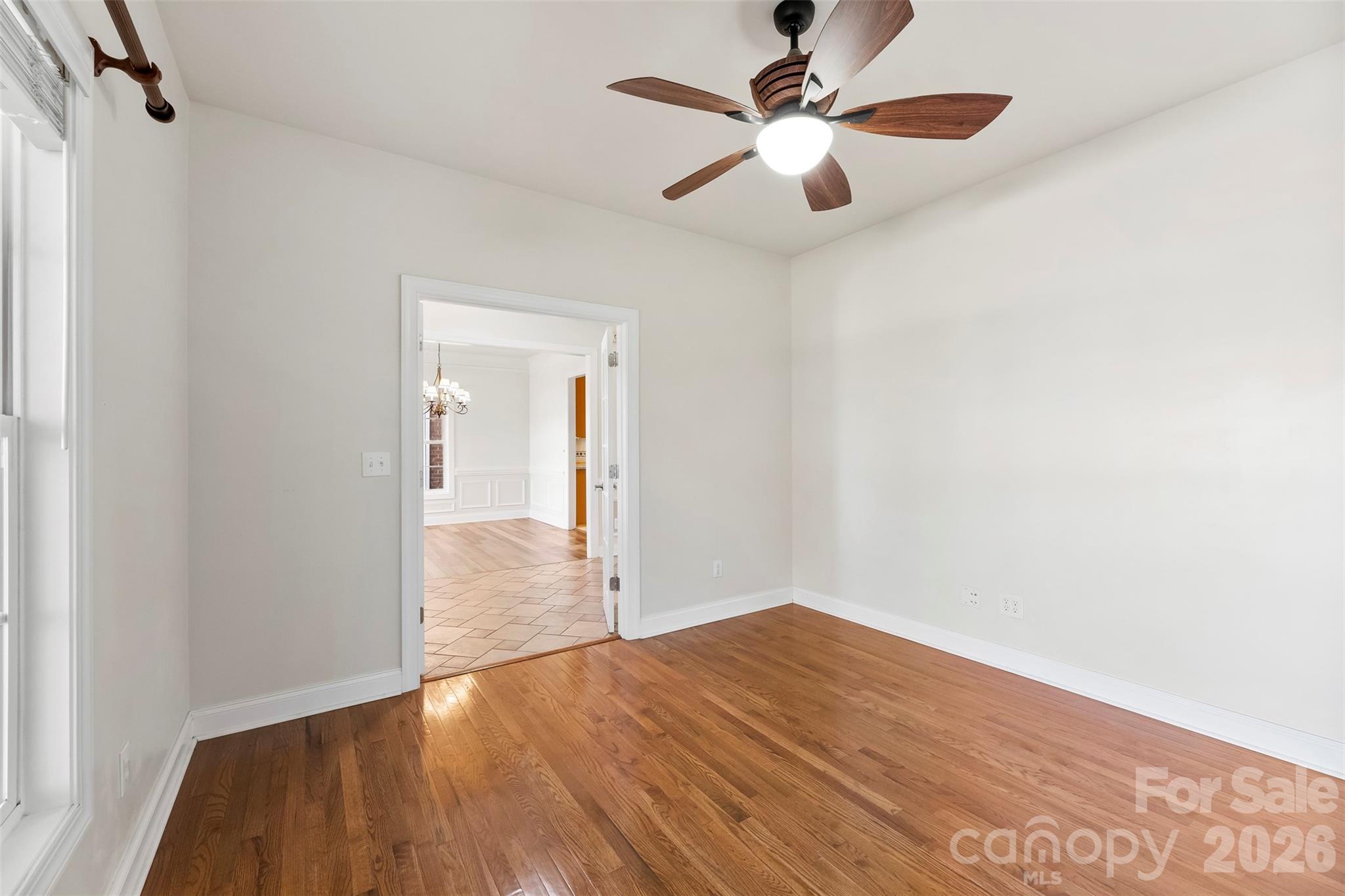 17858 Red Ridge Court Locust, NC 28097 - Photo 5 of 44 an empty room with wooden floor fan and a ceiling fan