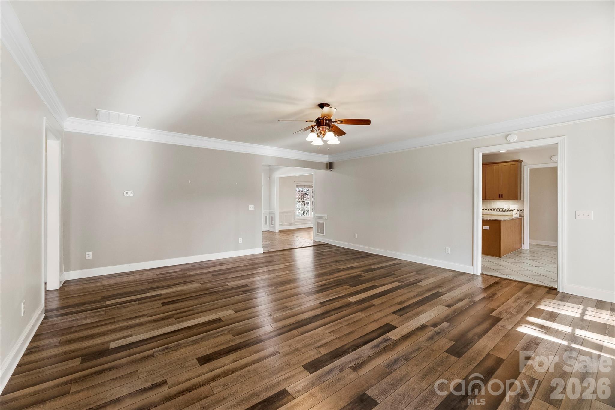 17858 Red Ridge Court Locust, NC 28097 - Photo 10 of 44 a view of an empty room with wooden floor and a ceiling fan