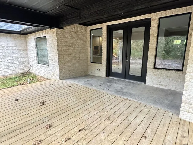 a view of a door of the house and floor to ceiling tree