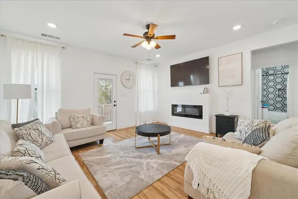 a living room with furniture a flat screen tv and a fireplace