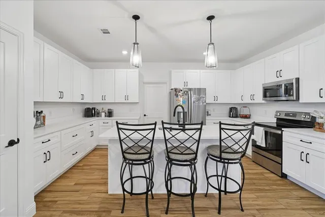 a view of a kitchen with electric appliances and wooden cabinets
