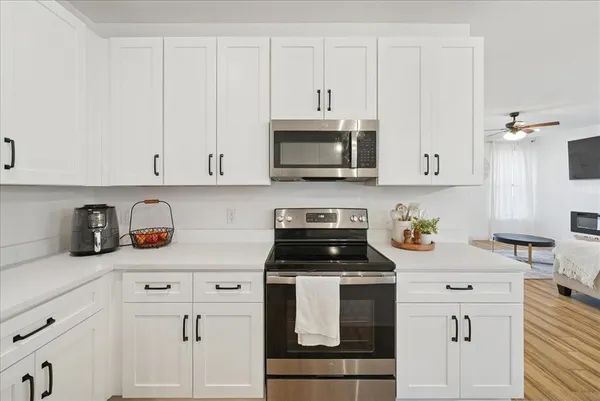 a kitchen with white cabinets and appliances