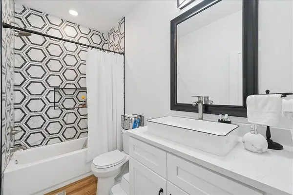 a bathroom with a sink a toilet and shower