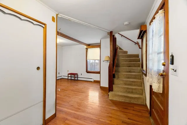 a view of a hallway with wooden floor and staircase