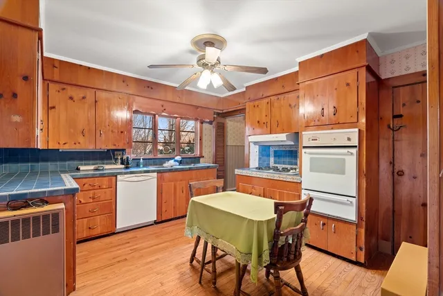a kitchen with stainless steel appliances granite countertop a kitchen island hardwood floor sink stove dining table and chairs