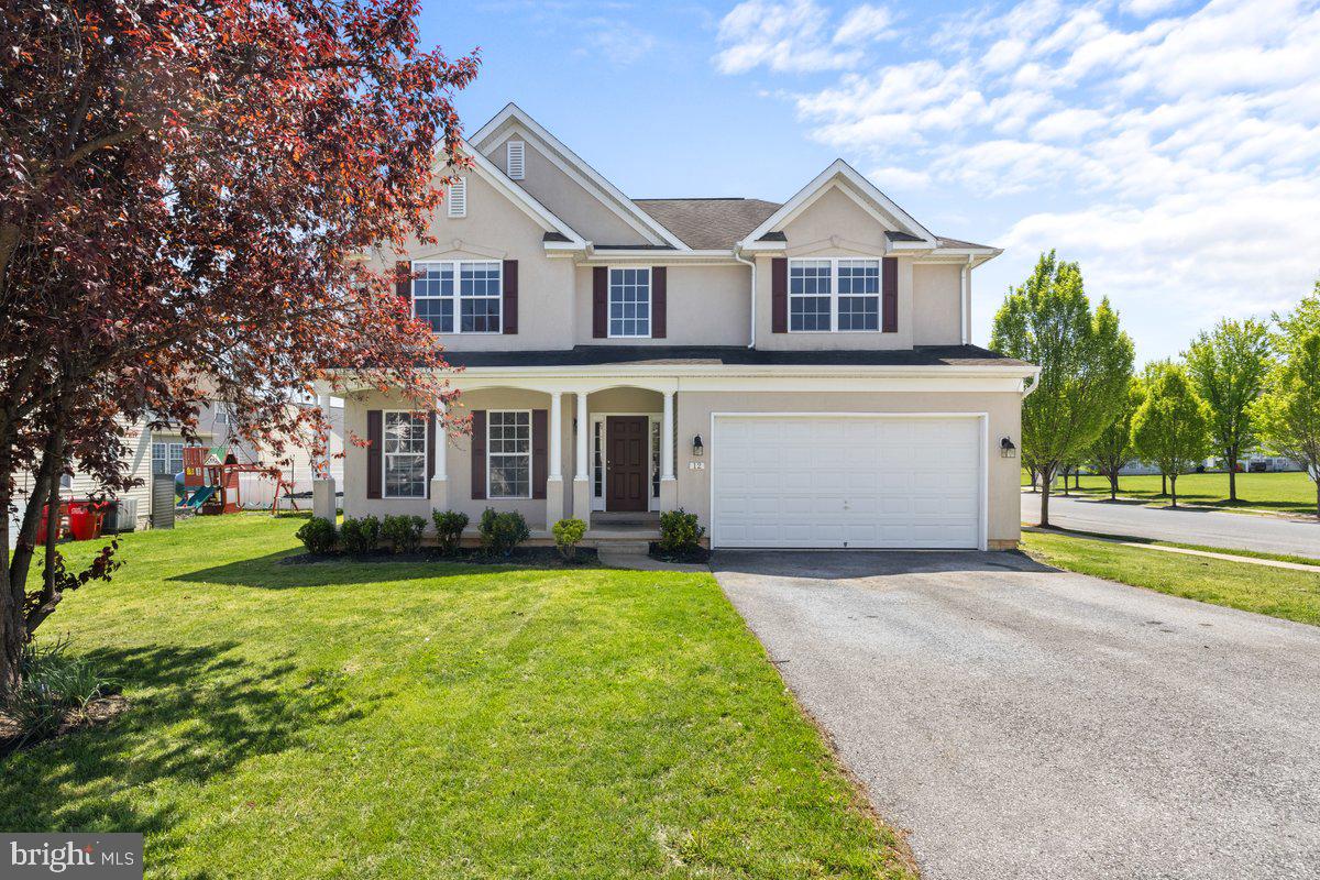 a front view of a house with a yard and trees
