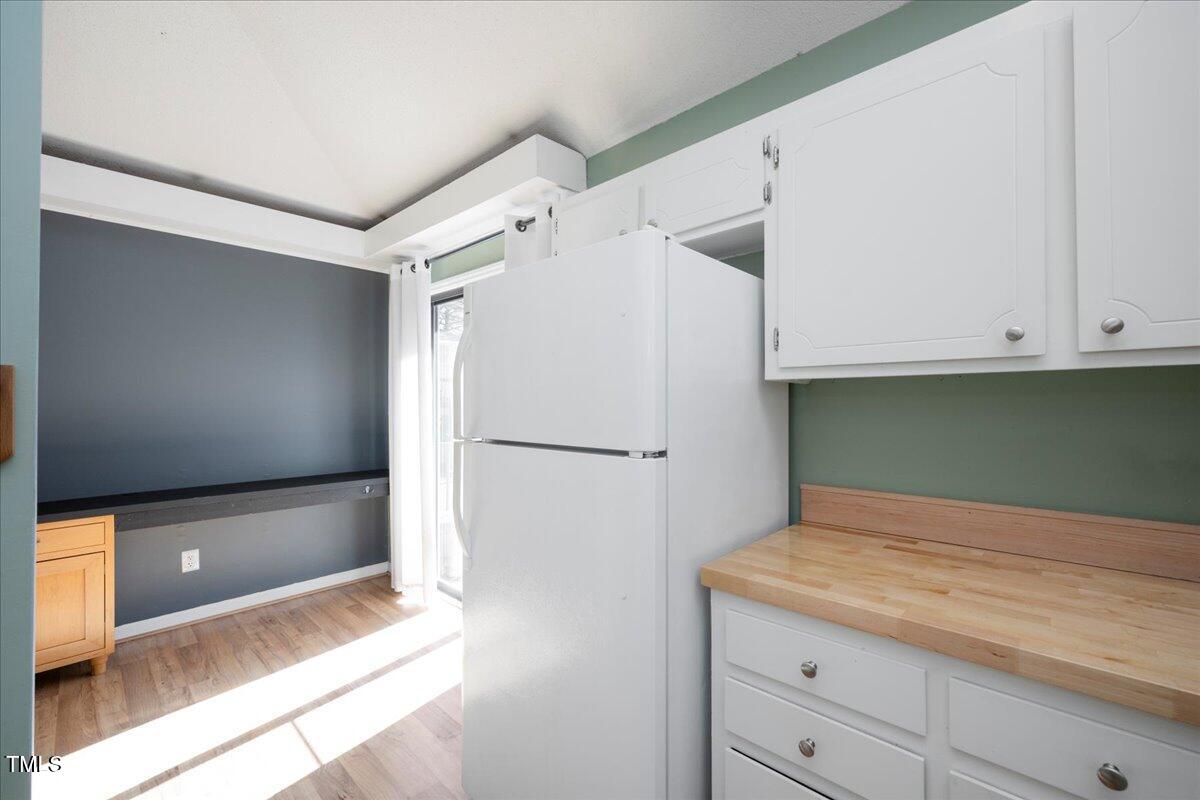 3501 Mill Run Raleigh, NC 27612 - Photo 11 of 24 a view of a kitchen with white cabinets and a refrigerator