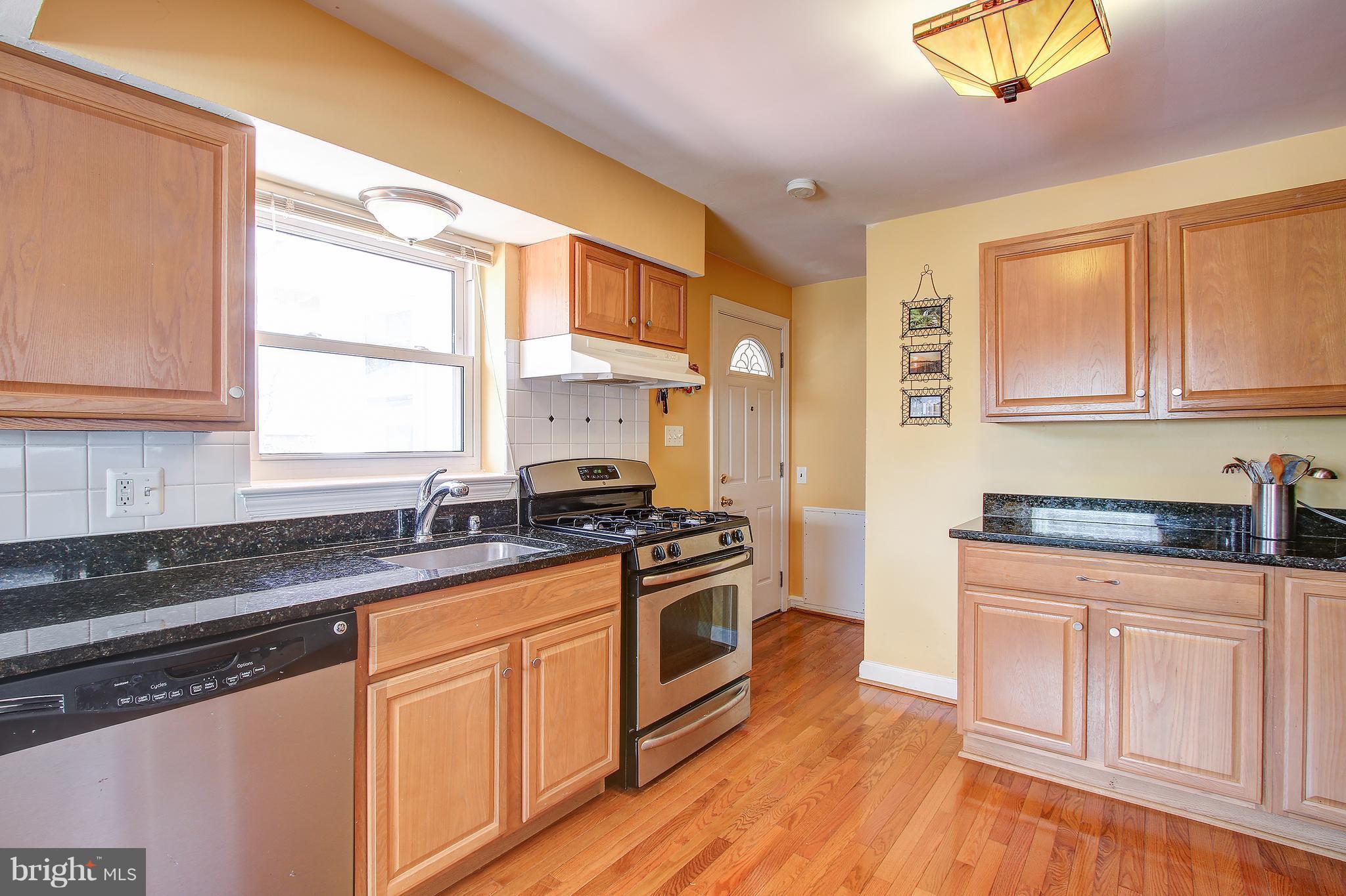 6018 Backlick Road Springfield, VA 22150 - Photo 7 of 26 a kitchen with stainless steel appliances granite countertop a stove a sink and a microwave
