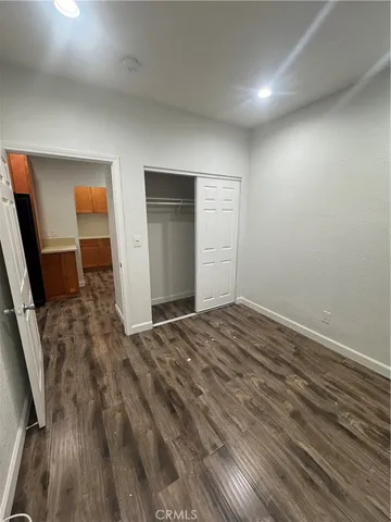an empty room with wooden floor and closet