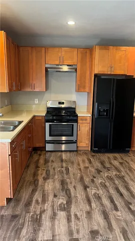 a kitchen with stainless steel appliances granite countertop a refrigerator and a stove