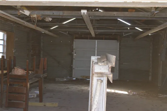 a view of a white house with a large tree