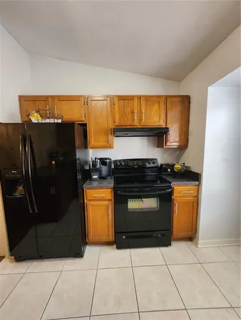 a kitchen with granite countertop a sink stove and cabinets