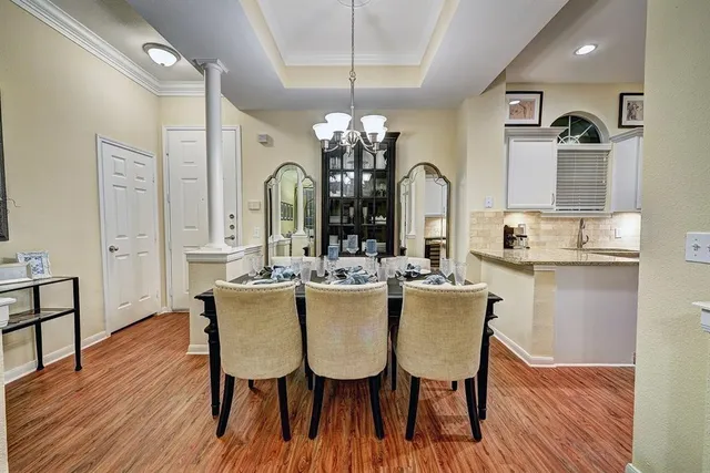 a dining room with furniture potted plants and wooden floor