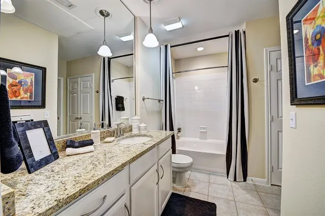a bathroom with a granite countertop sink mirror vanity and toilet