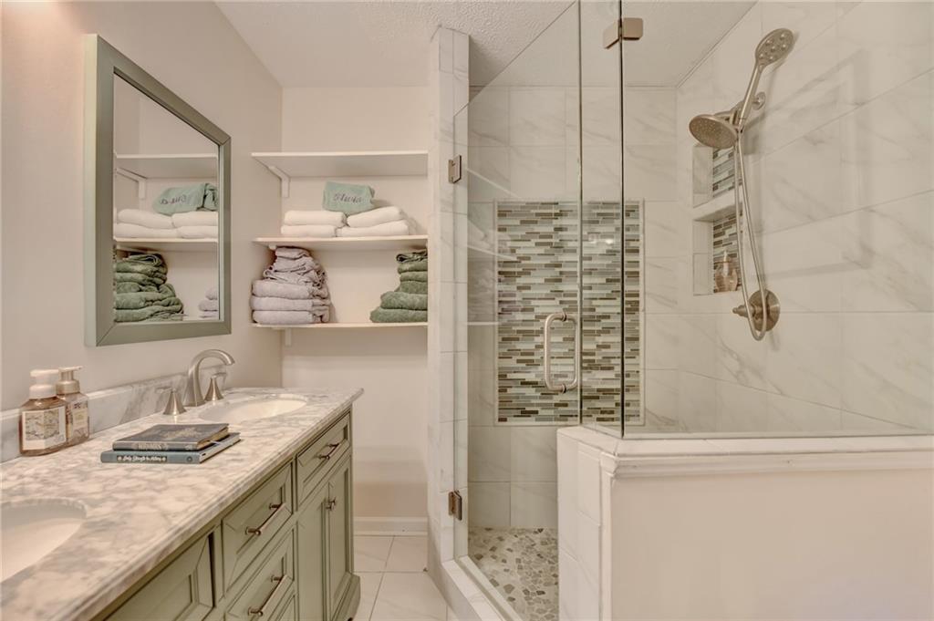 501 Wages Road Auburn, GA 30011 - Photo 32 of 50 a bathroom with a granite countertop sink a mirror and shower