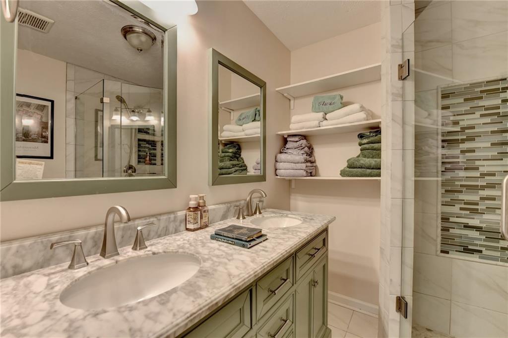 501 Wages Road Auburn, GA 30011 - Photo 33 of 50 a bathroom with a granite countertop sink a mirror and a shower