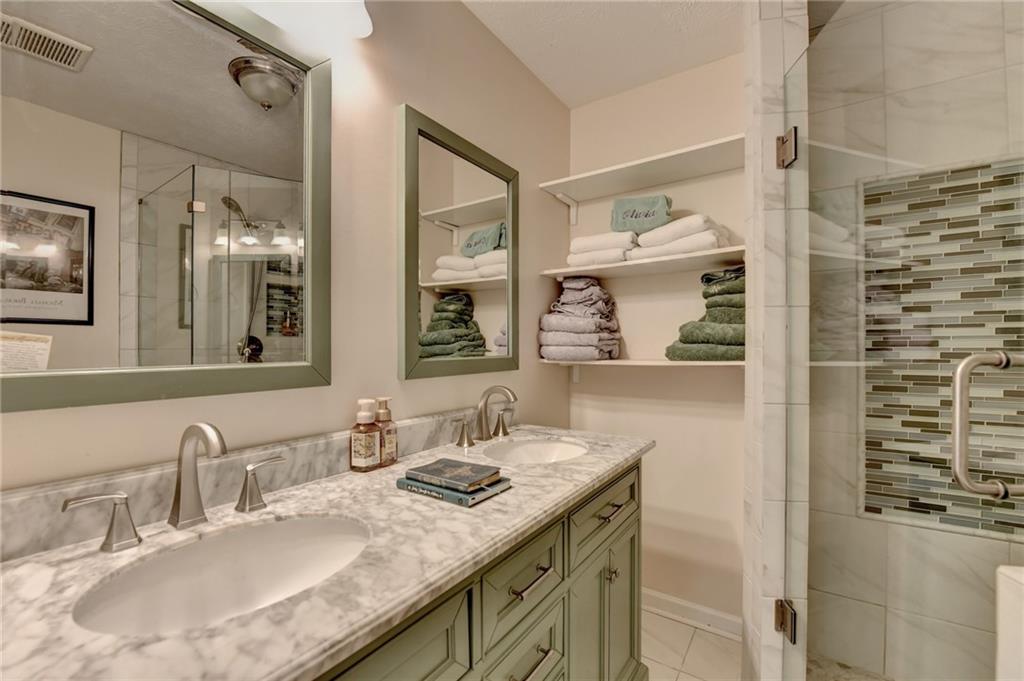 501 Wages Road Auburn, GA 30011 - Photo 35 of 50 a bathroom with a granite countertop sink a mirror and a shower