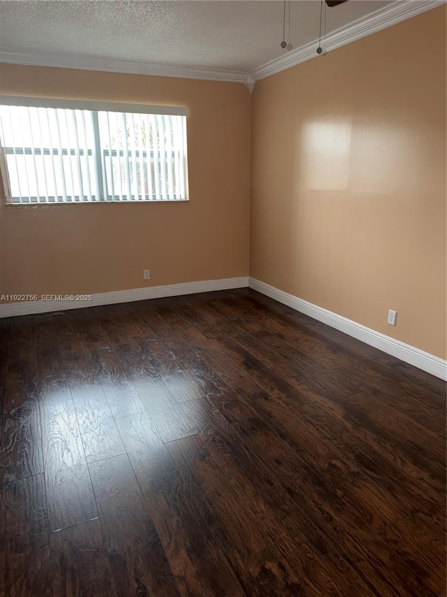 4042 Northwest 19th Street, Unit 305 Lauderhill, FL 33313 - Photo 5 of 8 a view of an empty room with wooden floor and a window