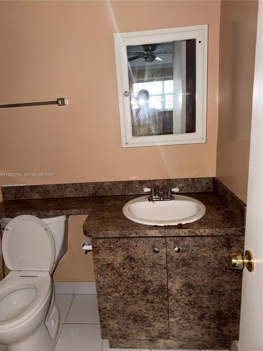 4042 Northwest 19th Street, Unit 305 Lauderhill, FL 33313 - Photo 7 of 8 a bathroom with a toilet sink and mirror