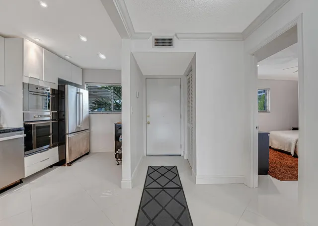 a living room with furniture a floor to ceiling window and a flat screen tv