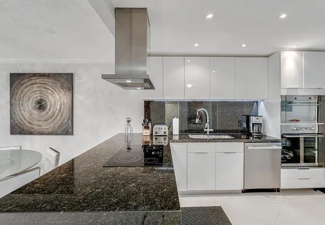 a kitchen with stainless steel appliances granite countertop a sink and stove