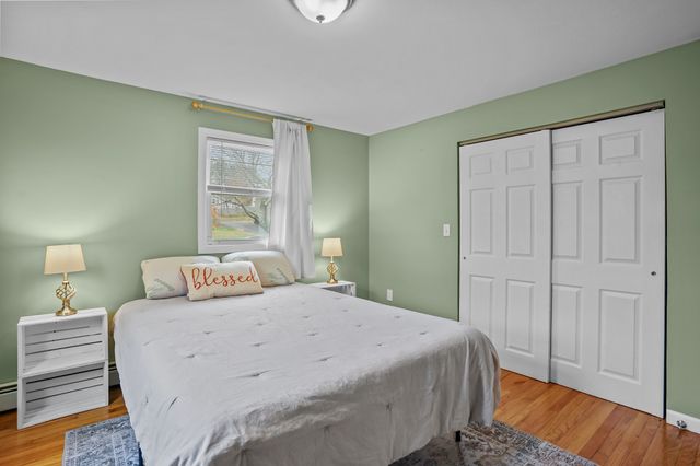 a bedroom with a bed and a wooden floor