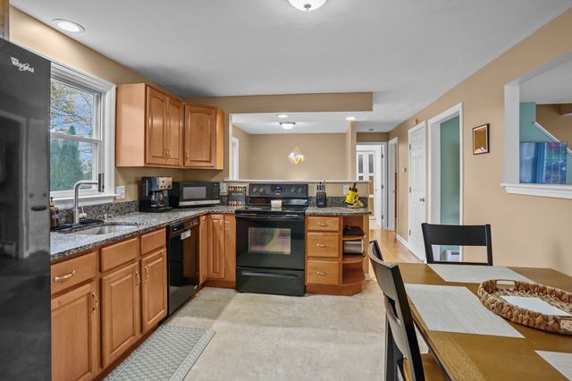 a kitchen with stainless steel appliances granite countertop a stove top oven a sink dishwasher and cabinets with wooden floor