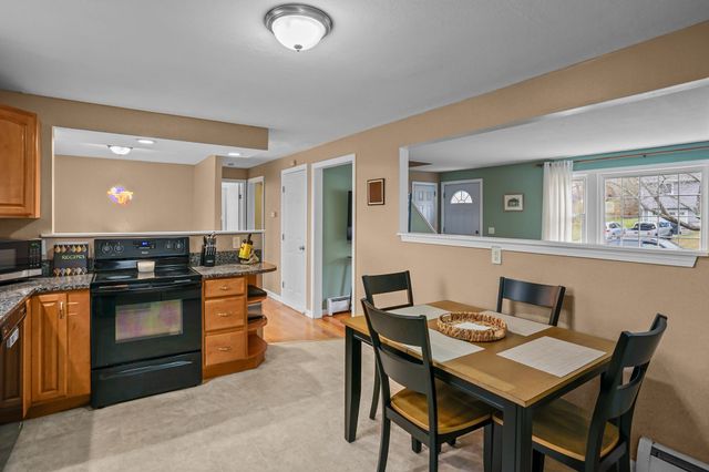a kitchen with granite countertop a table and chairs in it