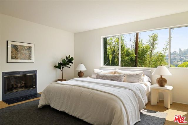 a bedroom with a large bed and a fireplace