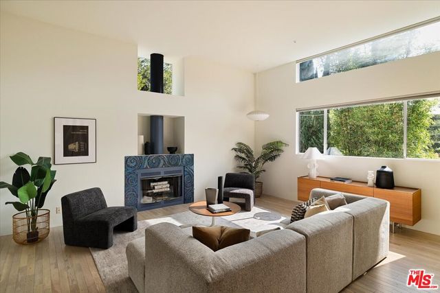 a living room with furniture fireplace and a large window