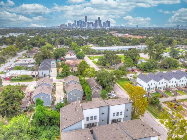 an aerial view of residential houses with outdoor space and ocean view