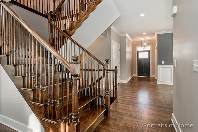 a view of staircase with wooden floor and white walls