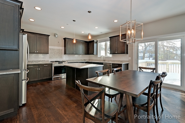 6340 Tennessee Avenue Willowbrook, IL 60527 - Photo 9 of 23 a kitchen with stainless steel appliances kitchen island granite countertop a dining table chairs and refrigerator