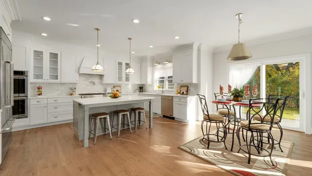 a dining room with stainless steel appliances kitchen island granite countertop a stove a refrigerator a kitchen island with a dining table and chairs