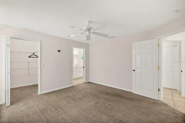 a view of an empty room with a ceiling fan