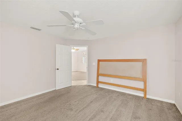 an empty room with fan and windows