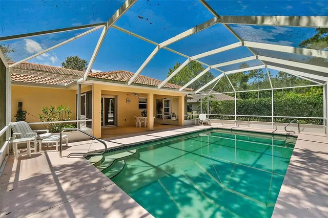 a view of a house with backyard and sitting area