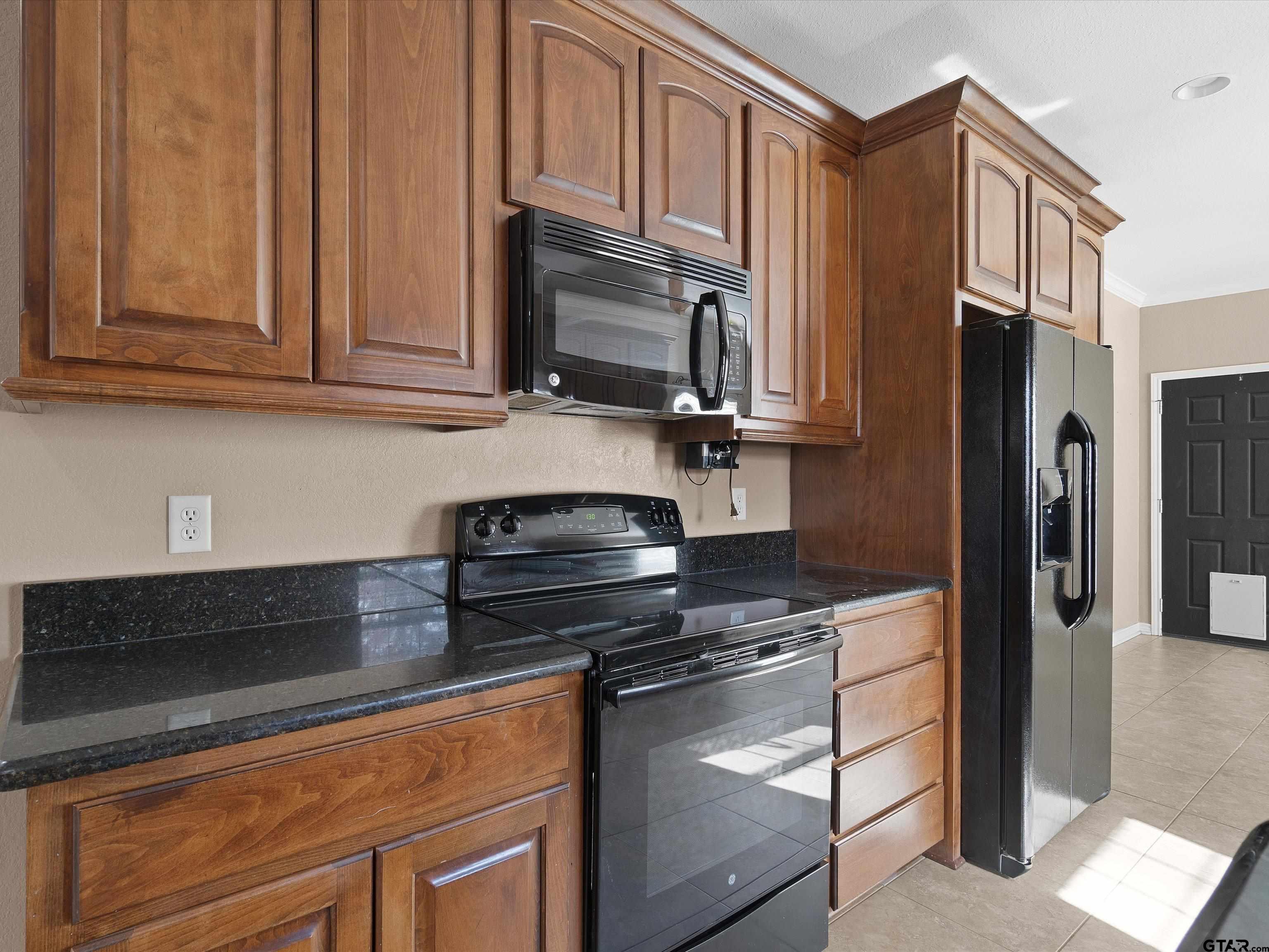 1703 Azalea Street Gilmer, TX 75644 - Photo 1 of 34 a kitchen with stainless steel appliances granite countertop a refrigerator stove and cabinets