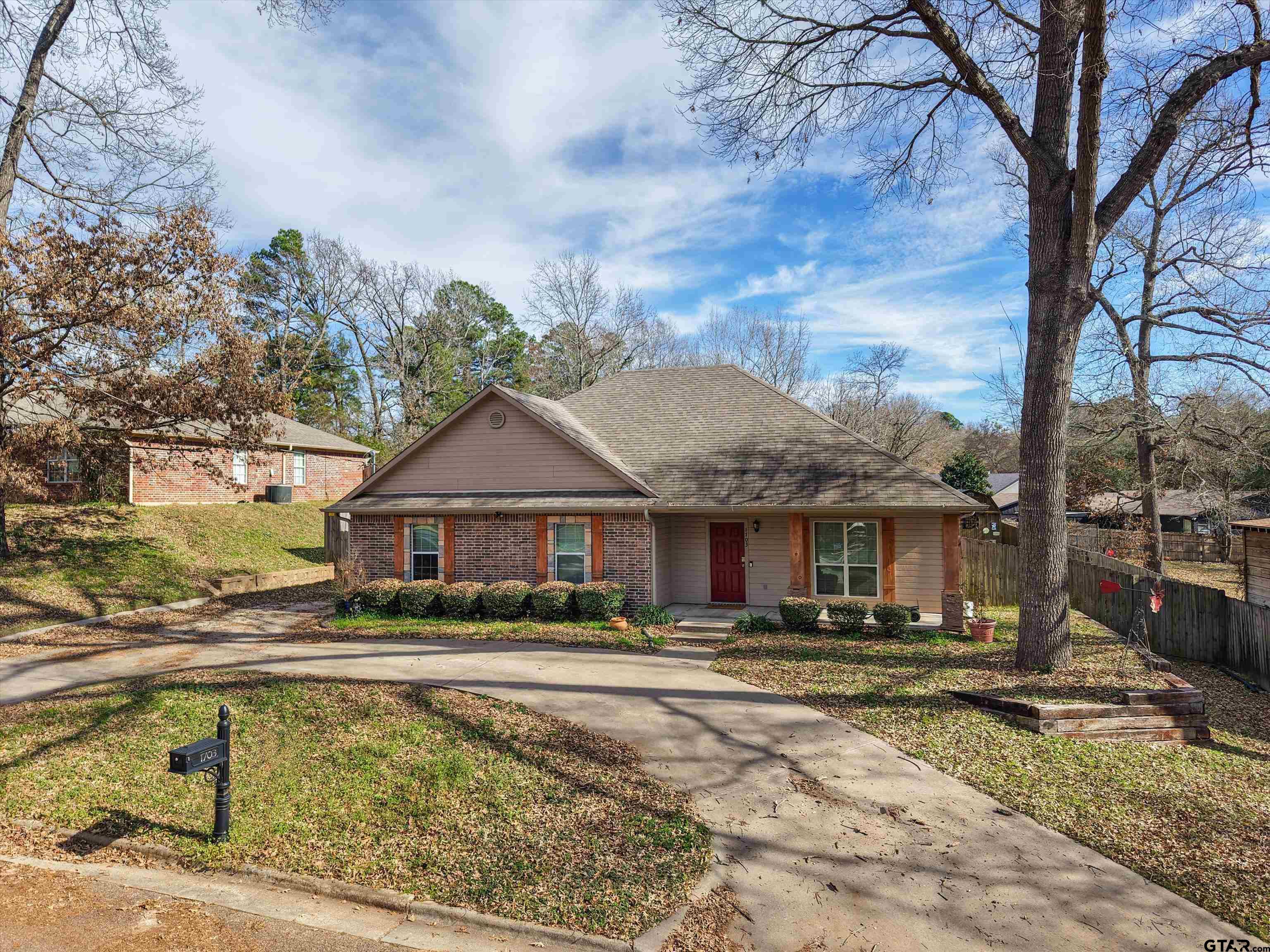 1703 Azalea Street Gilmer, TX 75644 - Photo 18 of 34 a front view of a house with a yard table and chairs