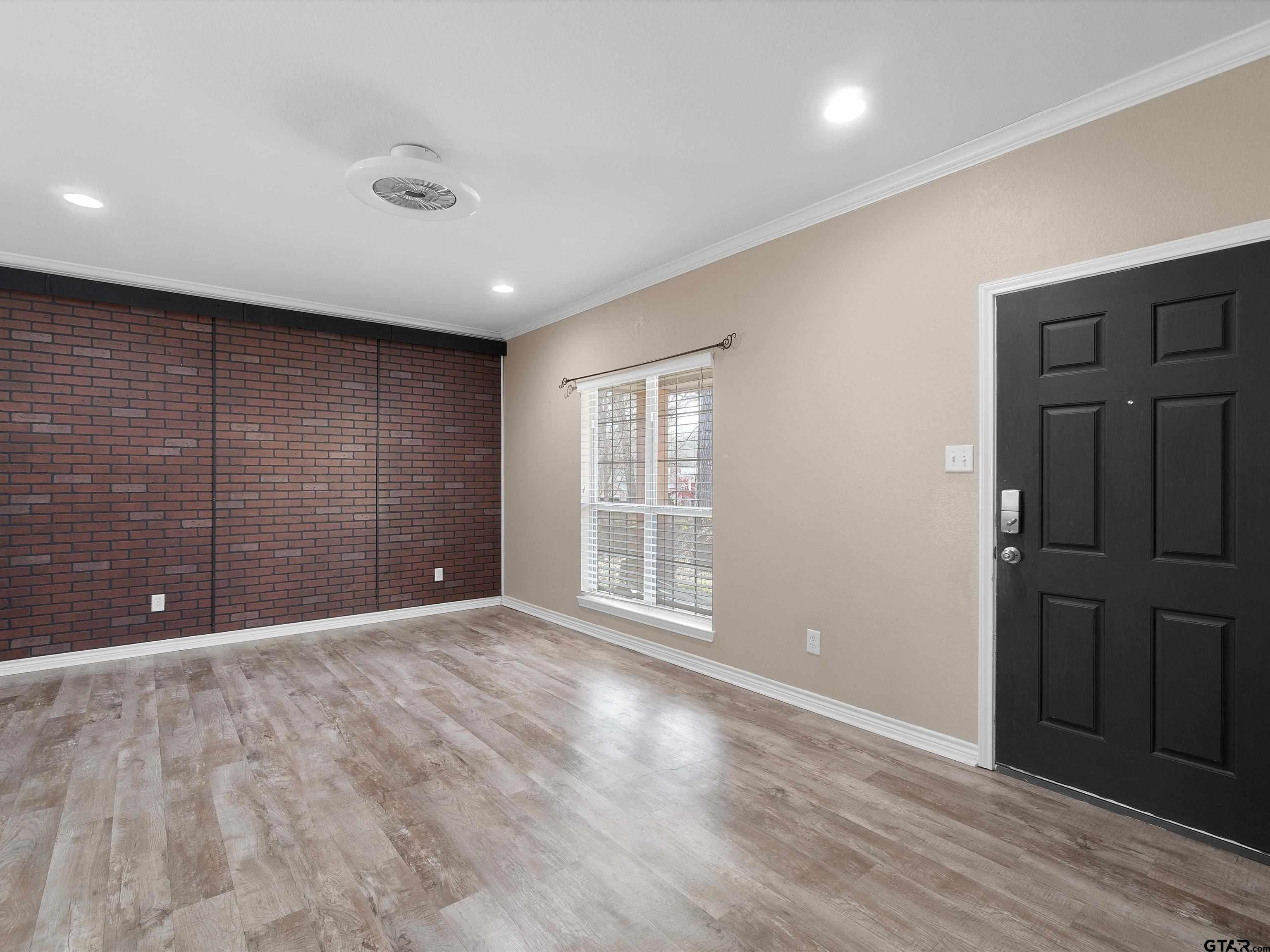 1703 Azalea Street Gilmer, TX 75644 - Photo 21 of 34 a view of an empty room with wooden floor and a bathroom
