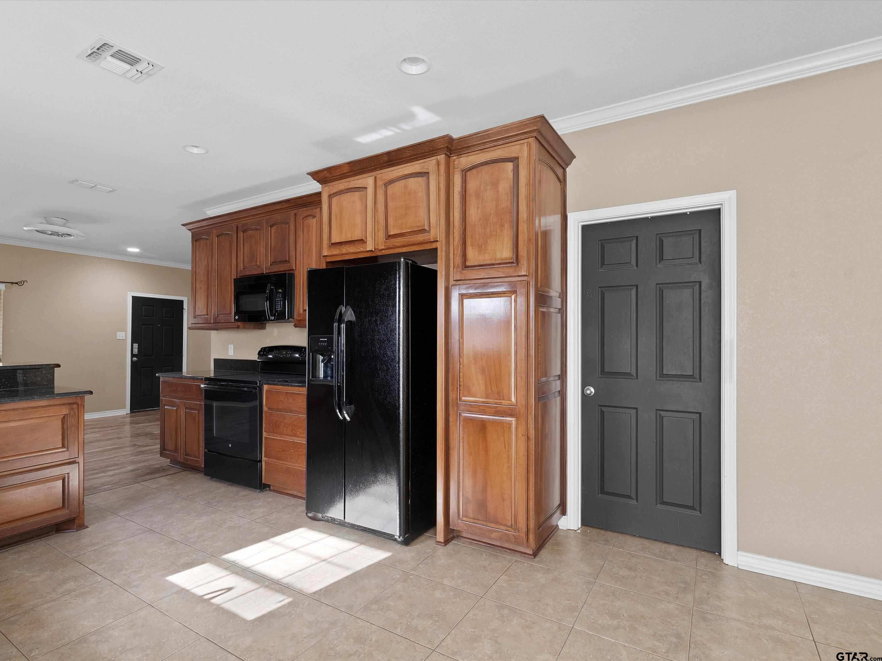1703 Azalea Street Gilmer, TX 75644 - Photo 25 of 34 a kitchen with stainless steel appliances kitchen island granite countertop a refrigerator and a stove top oven