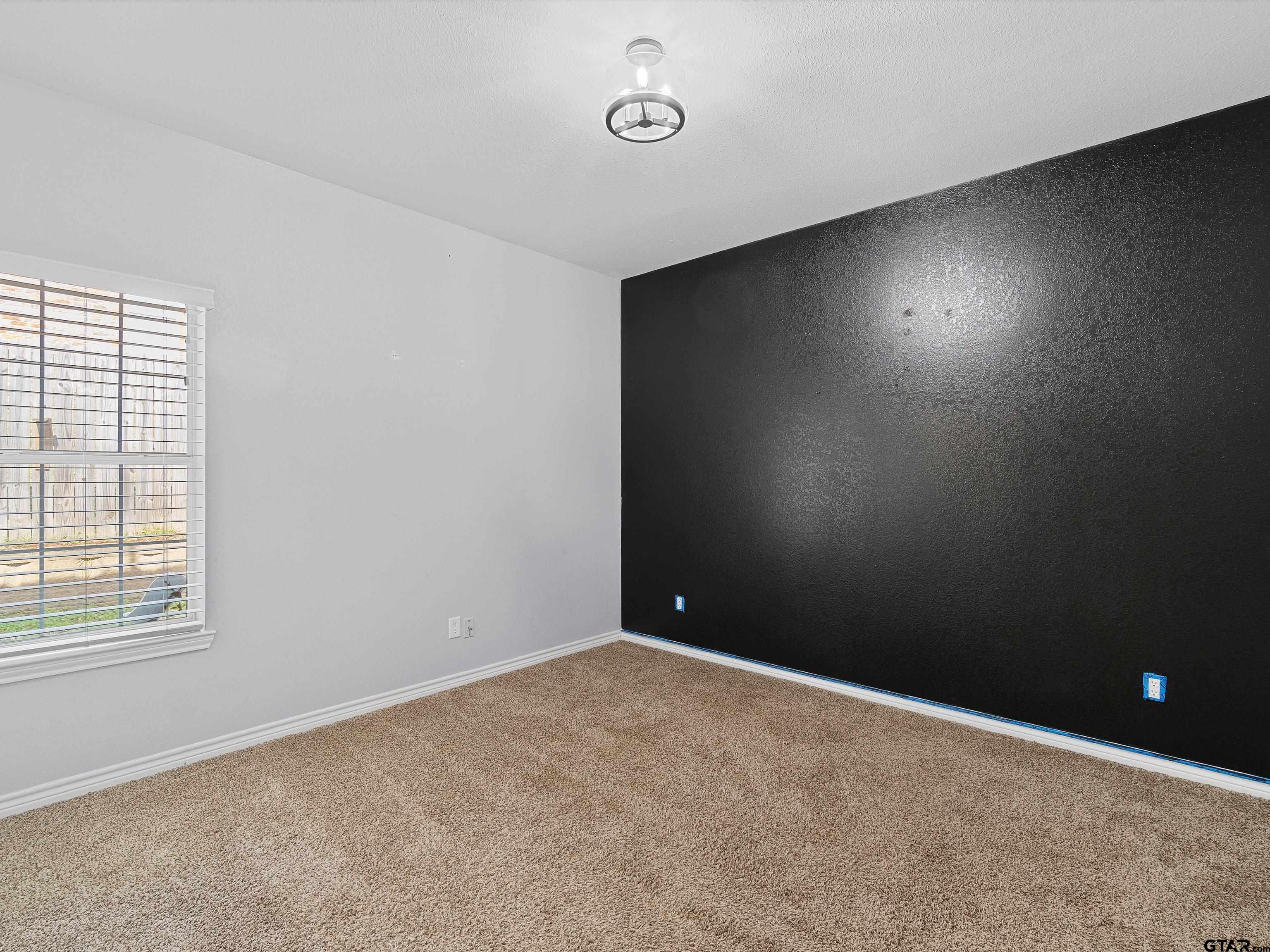 1703 Azalea Street Gilmer, TX 75644 - Photo 3 of 34 an empty room with a window and a fan