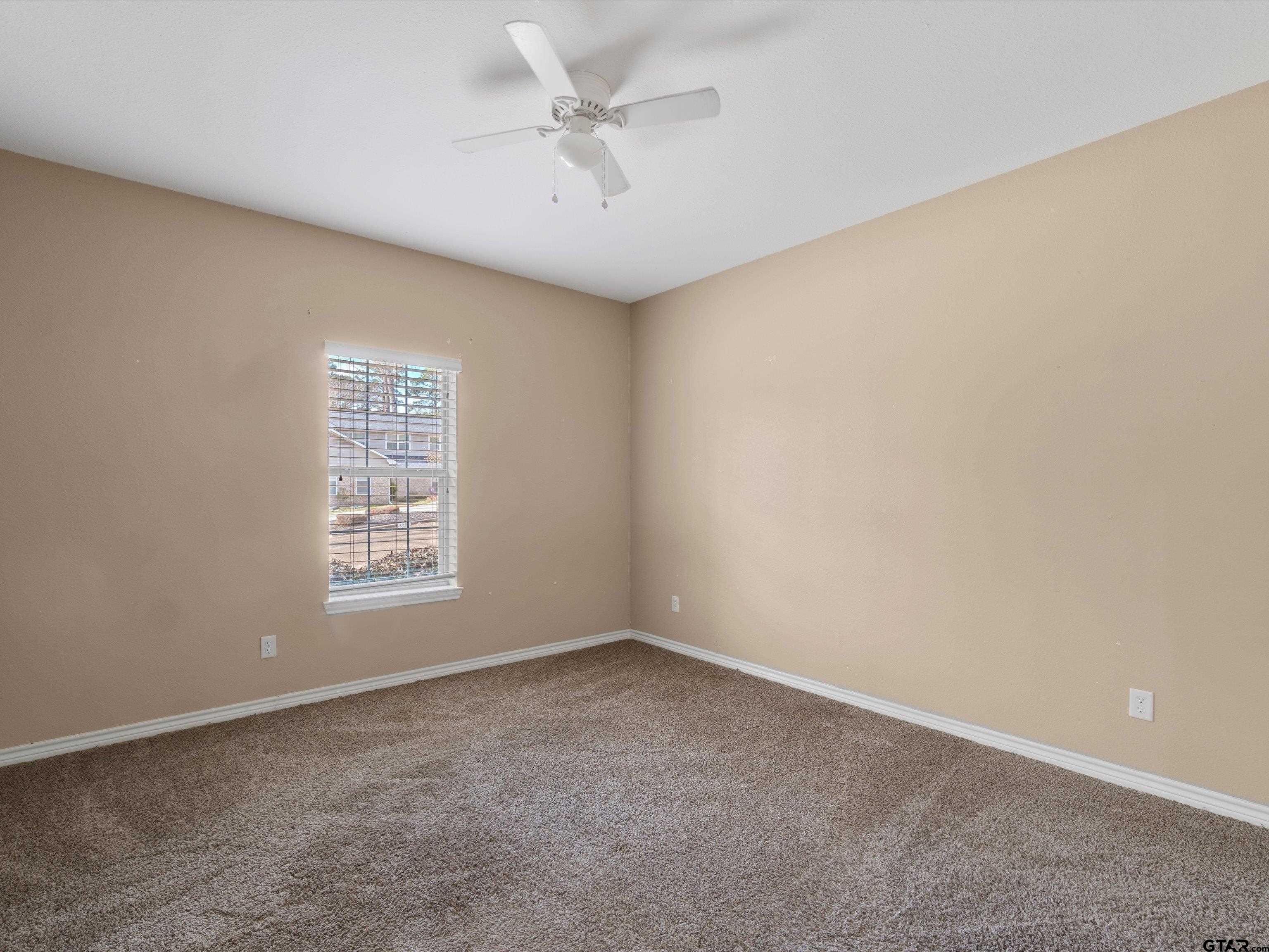 1703 Azalea Street Gilmer, TX 75644 - Photo 31 of 34 an empty room with a window and a ceiling fan